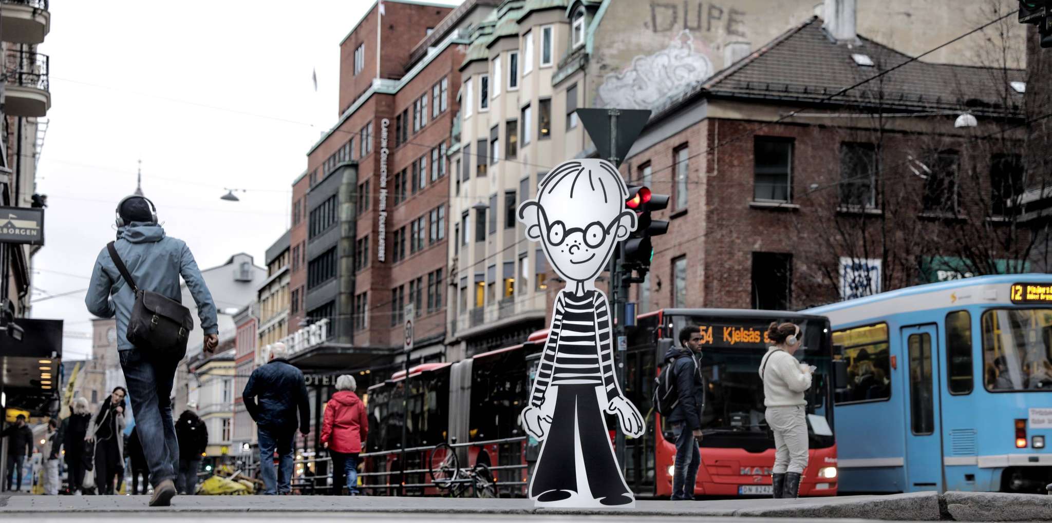 Foto av pappfiguren Tim med bybilde i bakgrunnen