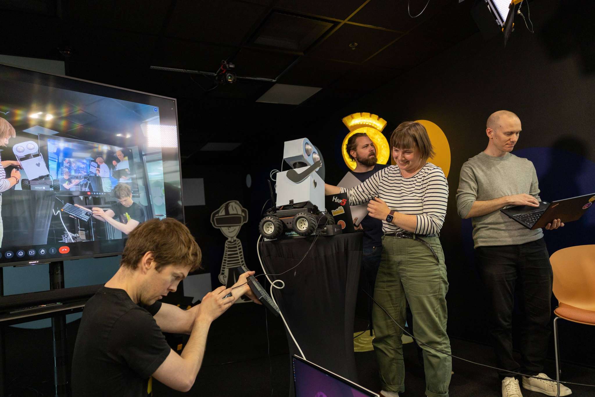 Utviklerteam som forsøker å få en robot til å oppføre seg som den skal, foto