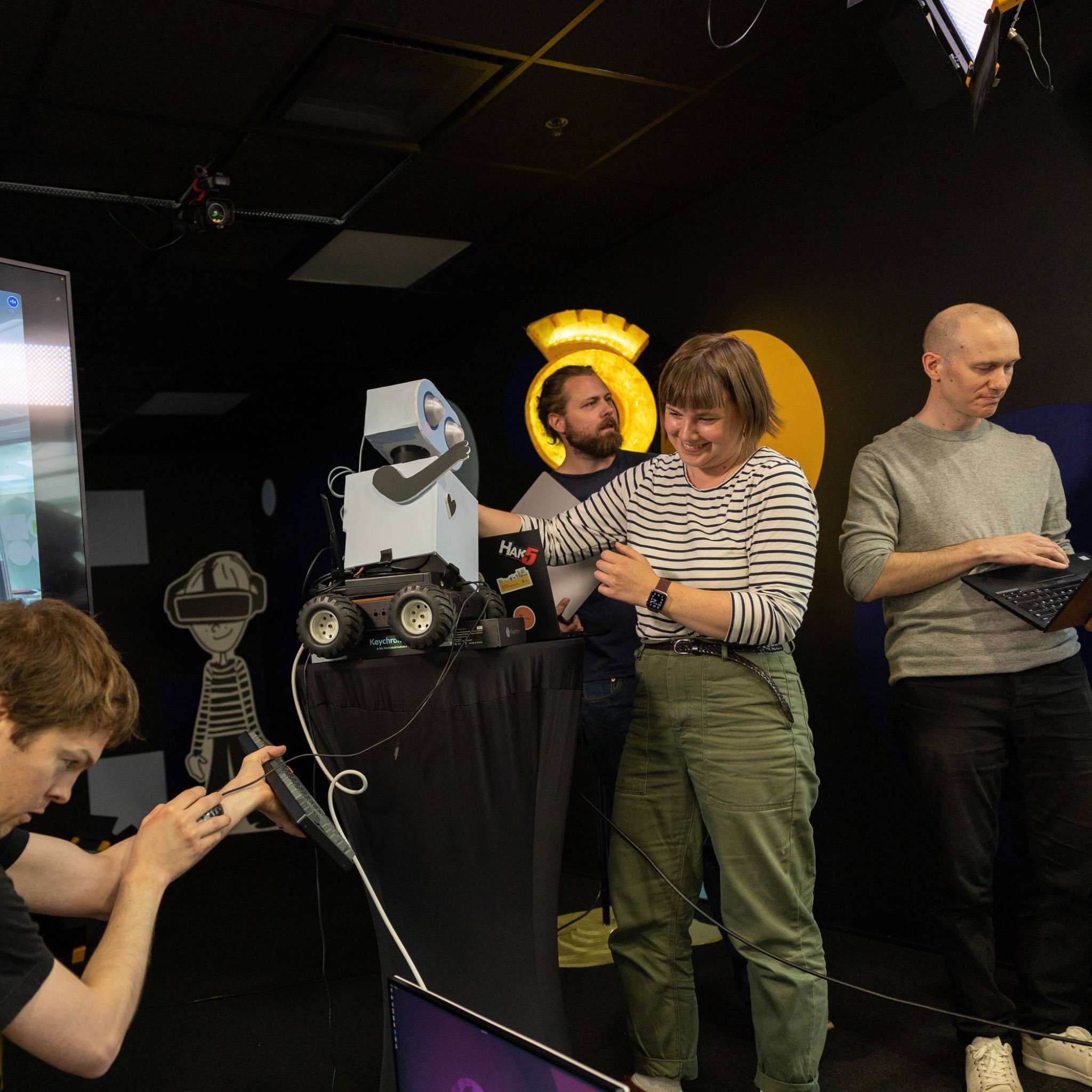 Utviklerteam som forsøker å få en robot til å oppføre seg som den skal, foto